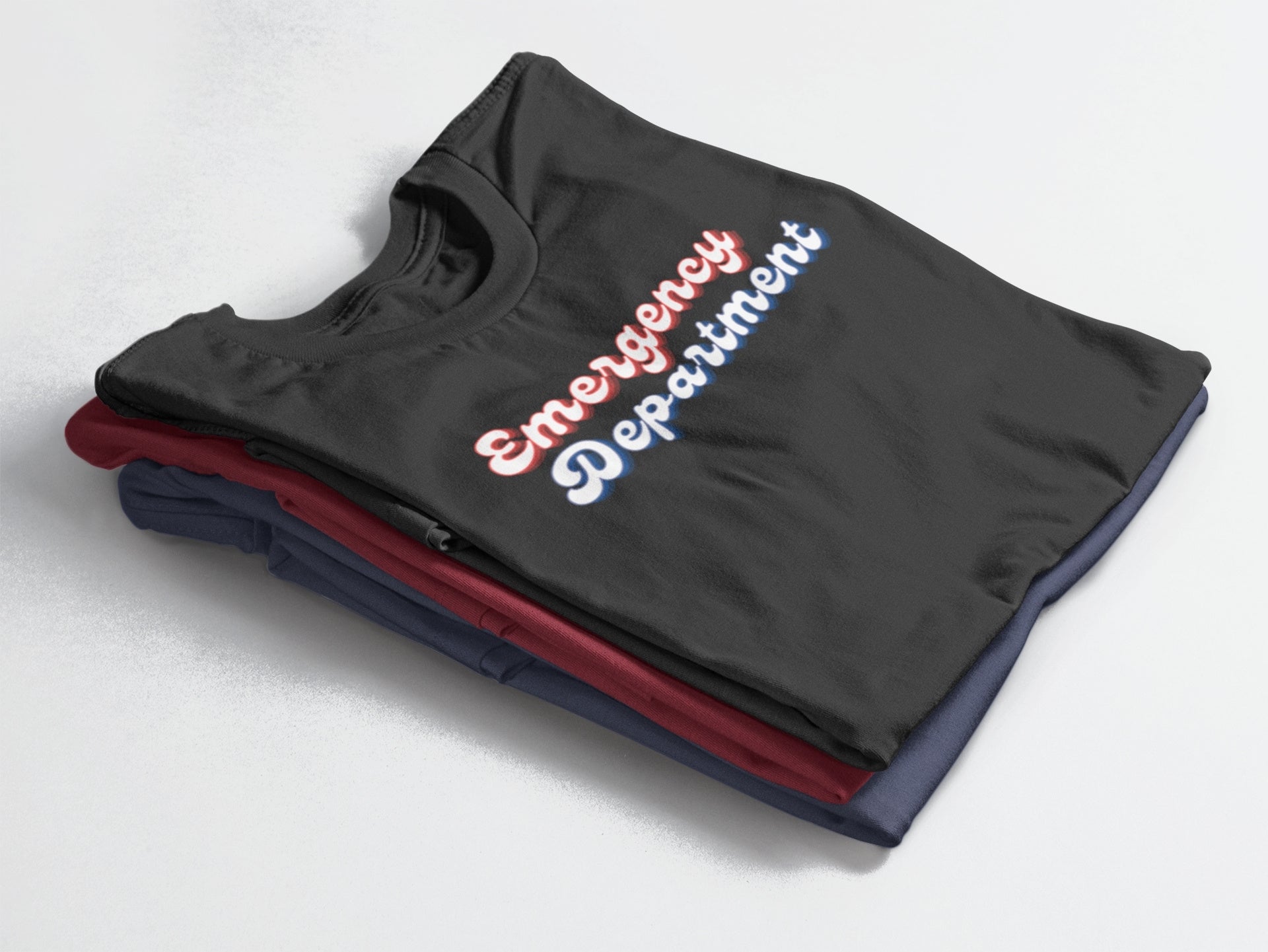 Folded black tank top with 'Emergency Department' text on a light gray background